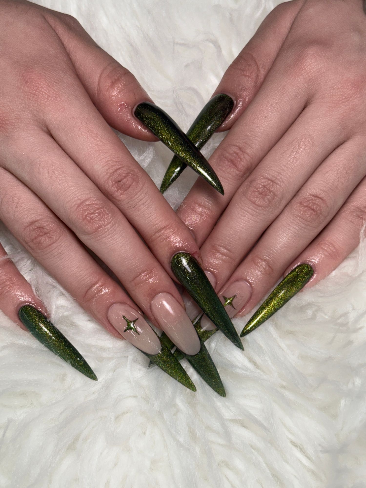 Long emerald green cat eye stiletto nails with gold star accents