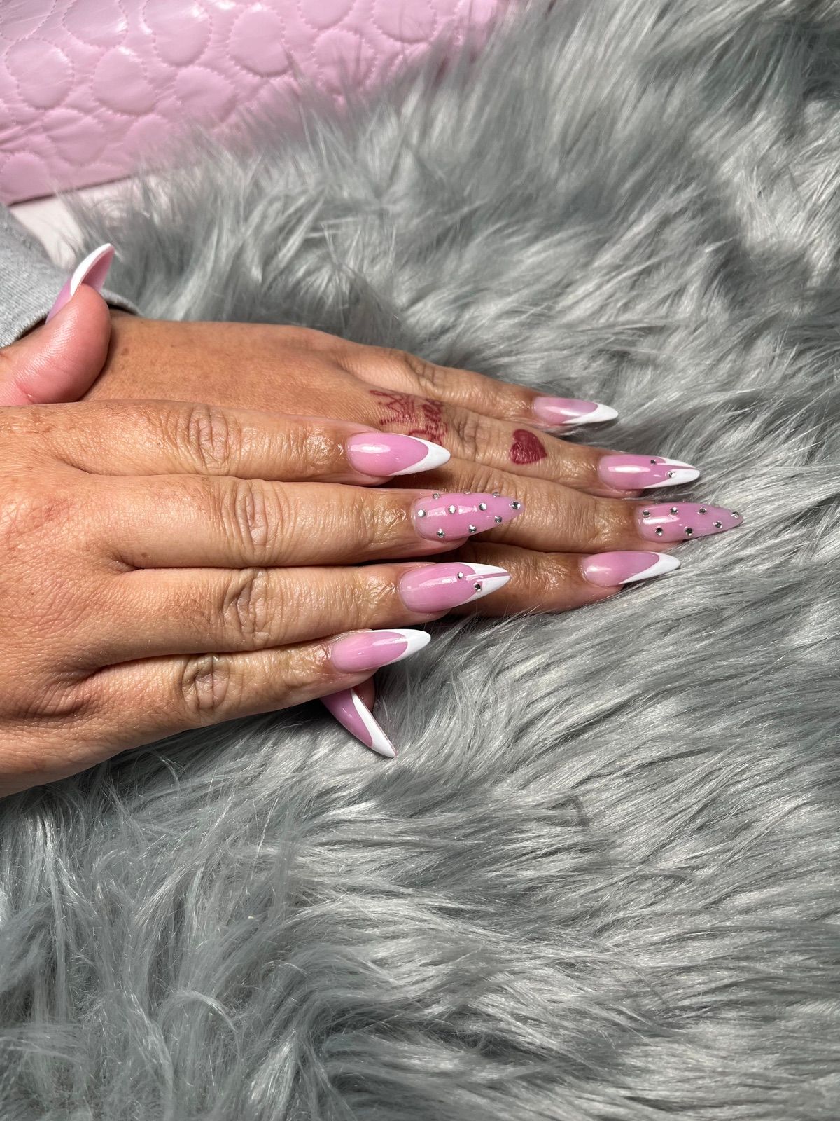 Long pink almond nails with white French tips and polka dot accents