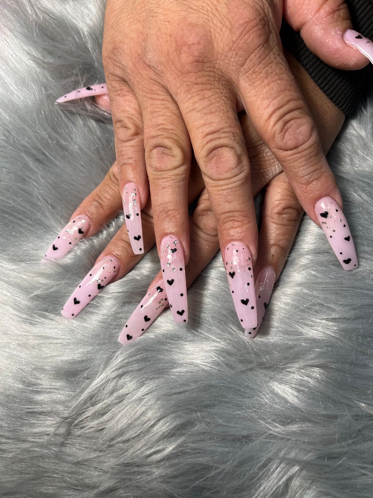 Long light pink coffin nails with tiny black hearts