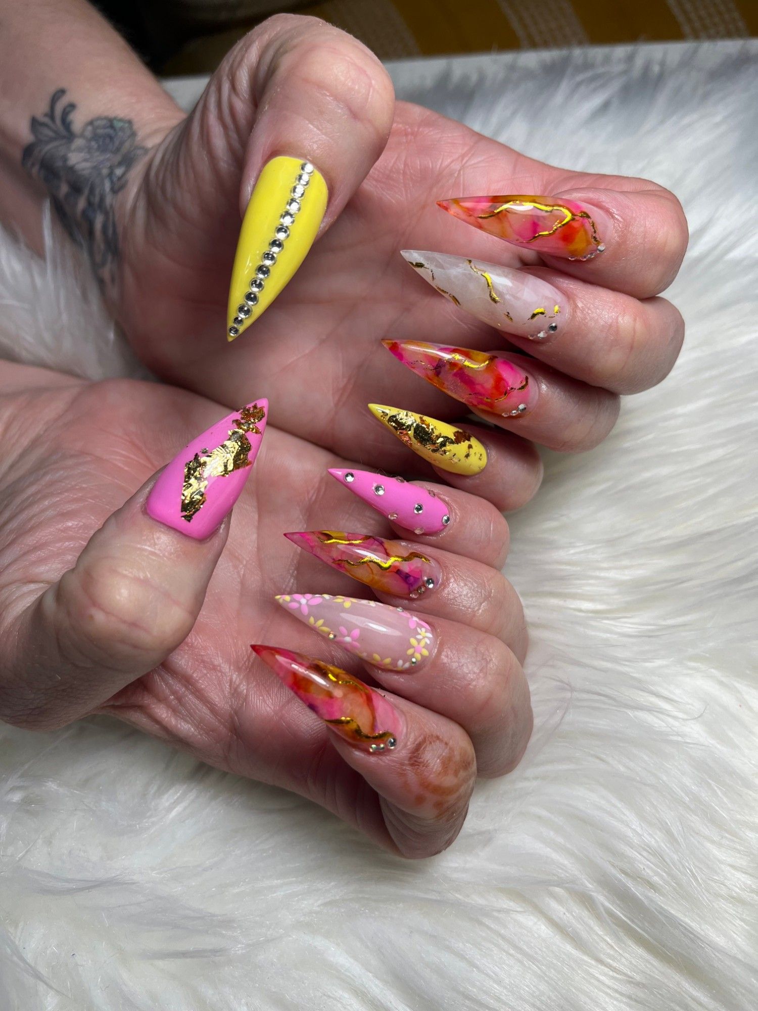 Pink, yellow and orange marble stiletto nails with gold foil and rhinestones
