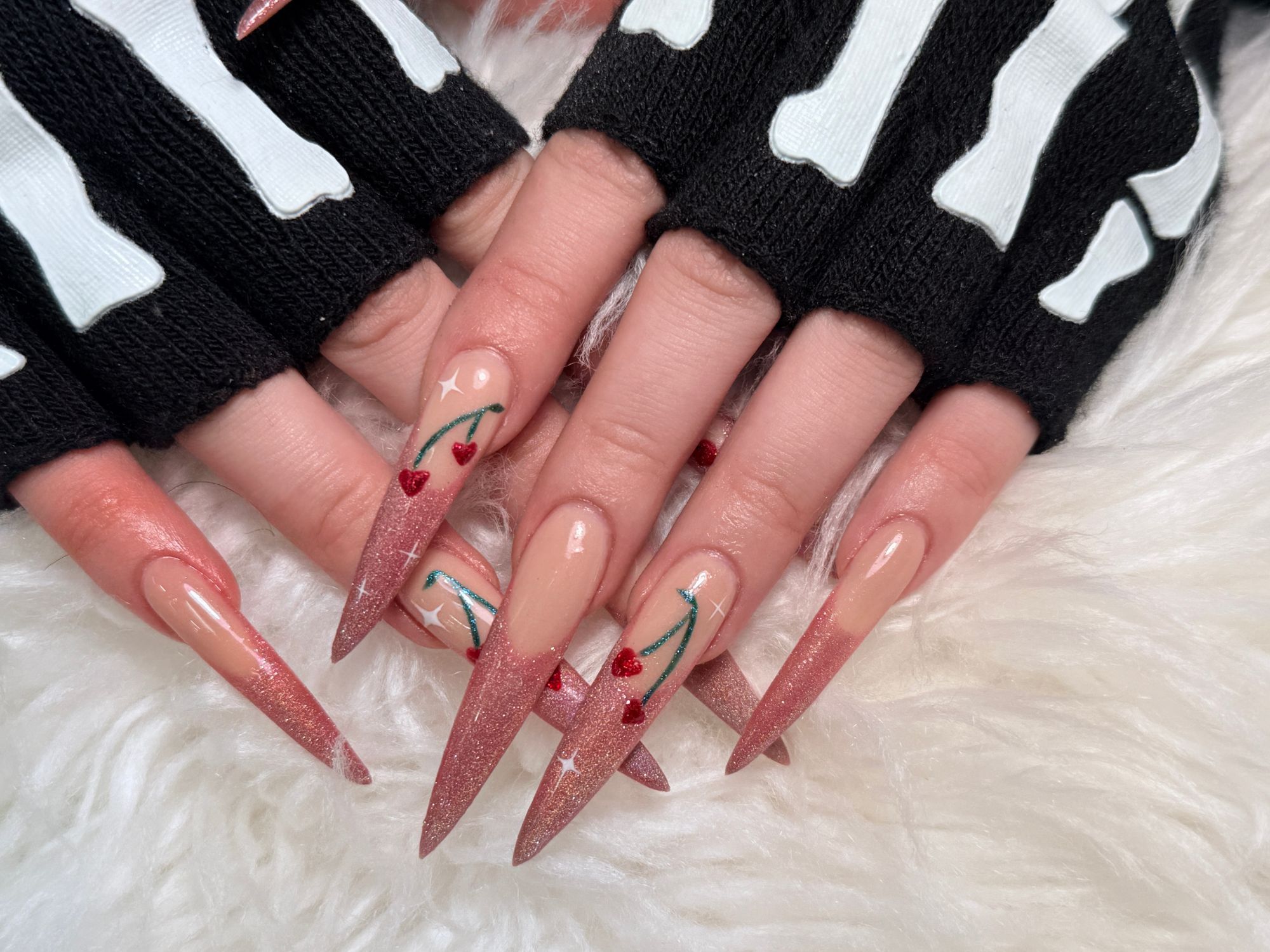 Long rose gold glitter French tip stiletto nails with hand-painted cherries